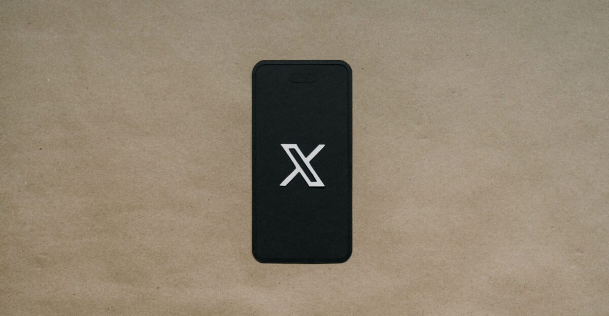 a black cell phone laying on top of a brown surface