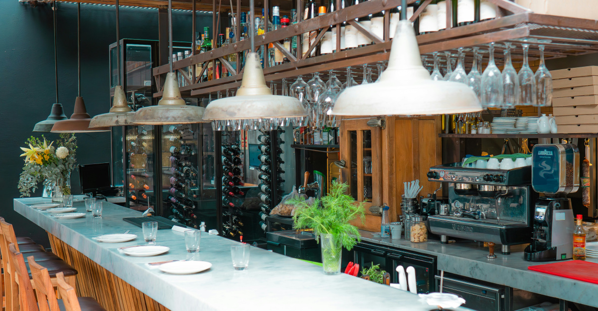 a bar with a bunch of wine glasses hanging from the ceiling