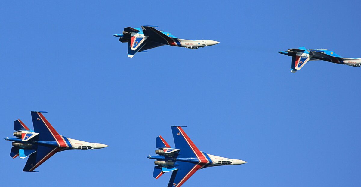 a group of fighter jets flying through a blue sky