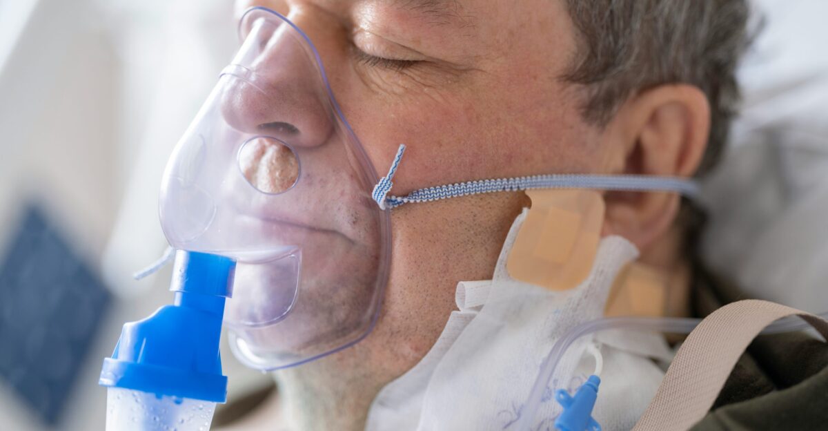 a man laying in a hospital bed with an oxygen tube attached to his face