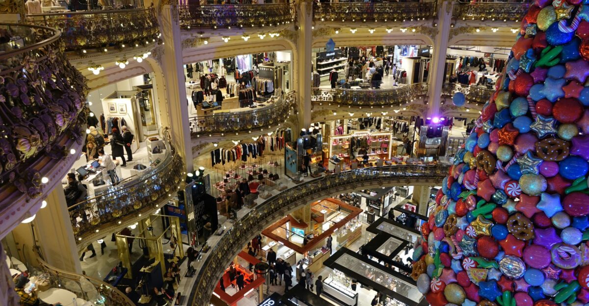 A large christmas tree in a mall filled with people