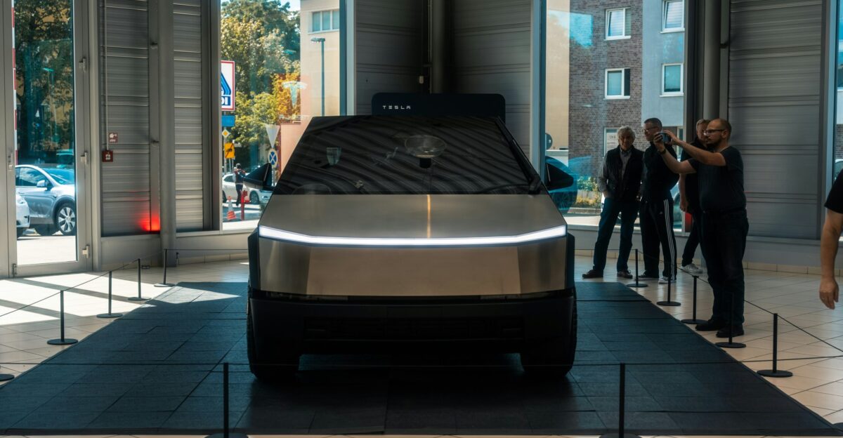A group of people standing around a car in a showroom