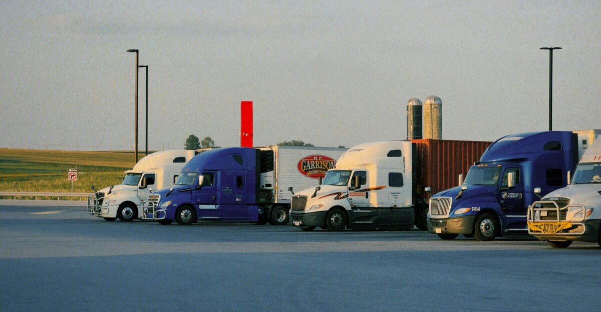 A row of semi trucks parked in a parking lot