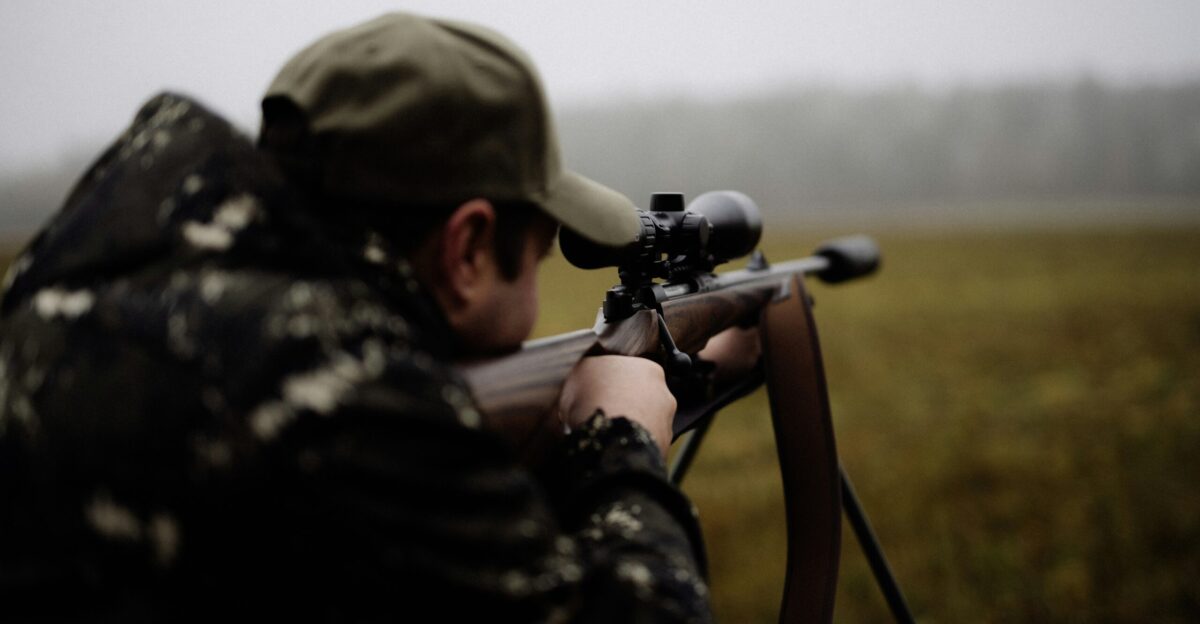 A man with a rifle in a field