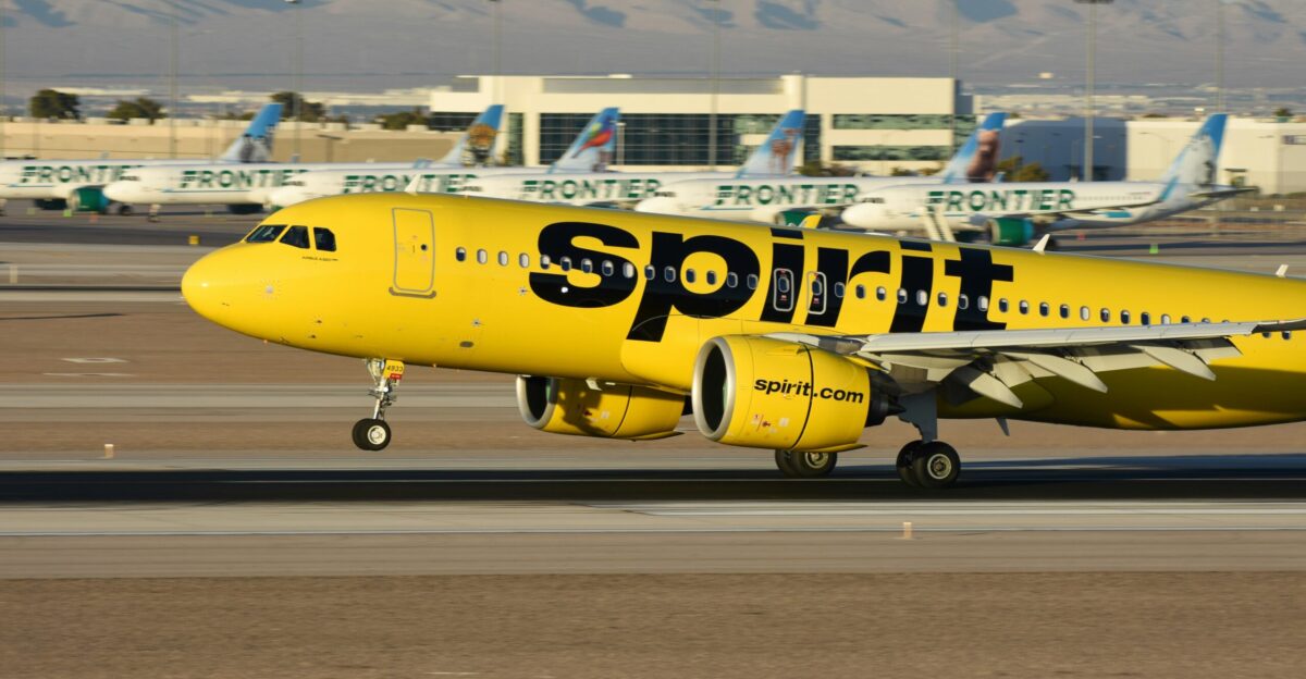 A yellow spirit airplane on the runway of an airport
