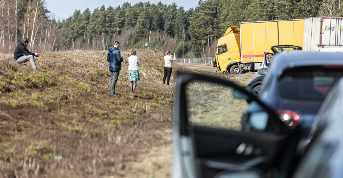 People investigate an accident near the roadside.