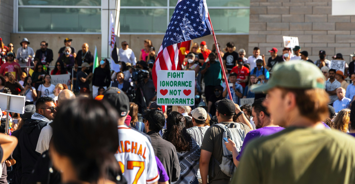 Protesters wave flags at an outdoor gathering.