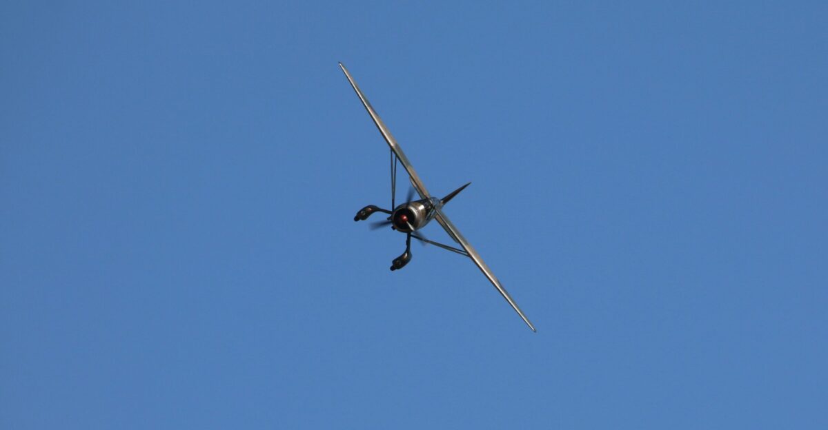 An airplane flies against a blue sky