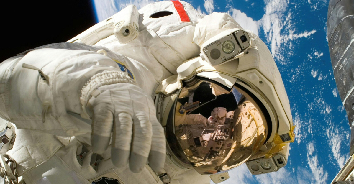 Astronaut floating in space during a spacewalk, visible Earth in the background.