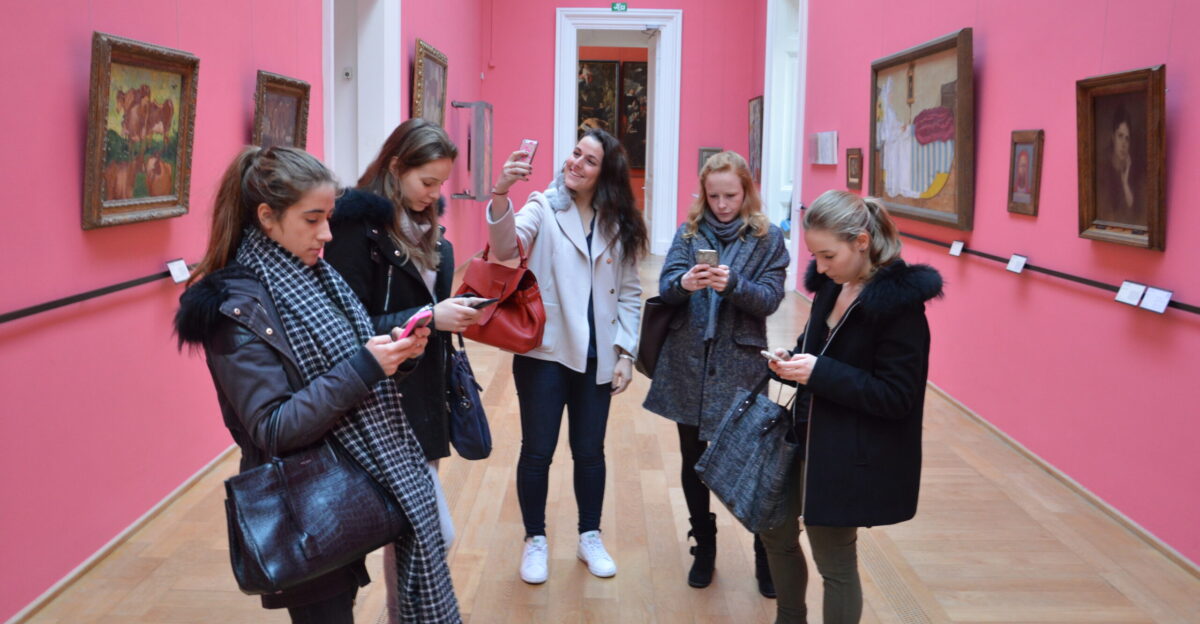 Generation-Z girls taking and sending photos while at the Lille Palace of Fine Arts museum