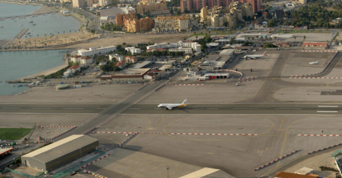 Composite image showing multiple stages of a <a href="https://en.wikipedia.org/wiki/Monarch_Airlines" class="extiw" title="en:Monarch Airlines">Monarch</a> <a href="https://en.wikipedia.org/wiki/Airbus_A320_family" class="extiw" title="en:Airbus A320 family">Airbus A320</a> aircraft taking off from the <a href="https://en.wikipedia.org/wiki/Gibraltar_Airport" class="extiw" title="en:Gibraltar Airport">Gibraltar Airport</a> (GIB/LXGB). Also visible in the centre is <a href="https://en.wikipedia.org/wiki/Winston_Churchill_Avenue" class="extiw" title="en:Winston Churchill Avenue">Winston Churchill Avenue</a> crossing the runway, the only street joining Gibraltar to the Spanish mainland. The camera viewpoint is from a terrace below the entrance to the <a href="https://en.wikipedia.org/wiki/Great_Siege_Tunnels" class="extiw" title="en:Great Siege Tunnels">Great Siege Tunnels</a> on the North face of the Rock of Gibraltar about 70 m above sea level. The composite image covers view of approximately 135°, ranging from almost due West at the left edge of the image to Northeast at the right edge.<br>The image was created by digitally combining 5 consecutive exposures taken over the course of 91 seconds starting at 18:22:47 local time. The original images were taken free hand with a <a href="https://en.wikipedia.org/wiki/Sony_Cyber-shot_DSC-R1" class="extiw" title="en:Sony Cyber-shot DSC-R1">Sony DSC-R1</a> at ISO 160 and a shutter speed of 1/250.