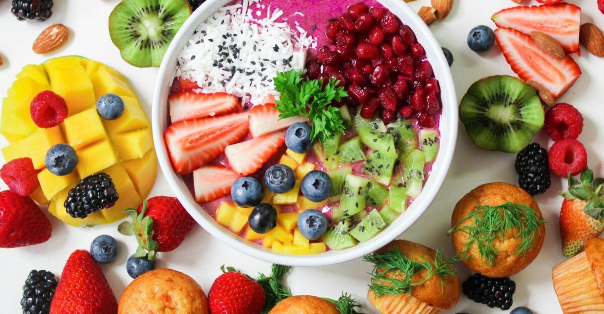 Vibrant smoothie bowl topped with assorted fresh fruits and muffins perfect for a healthy snack