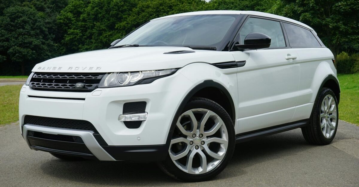 Stylish white Range Rover parked on a road in a green outdoor setting showcasing its luxury design
