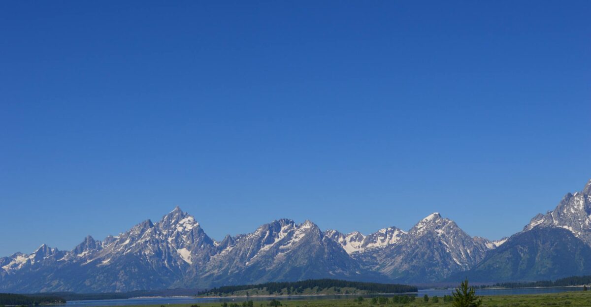 Breathtaking view of the snowcapped Teton Mountains with a blue sky background in Jackson WY