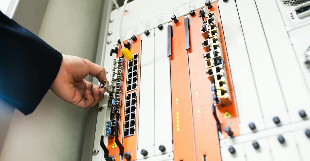 Close-up of a hand adjusting network equipment in a data center