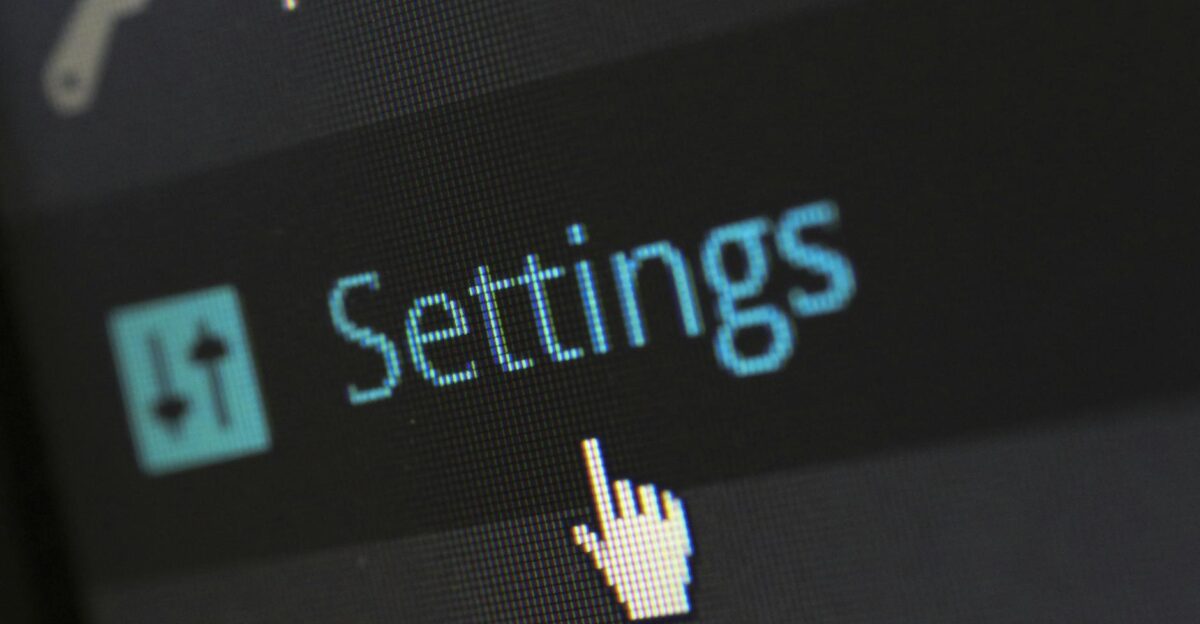 A close-up photo of a computer screen showing the settings button with a cursor hovering over it