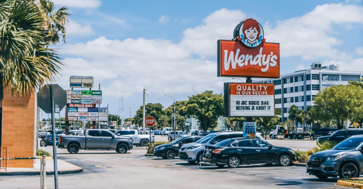 Wendy's parking area crowded with cars under a clear blue sky in Orlando.