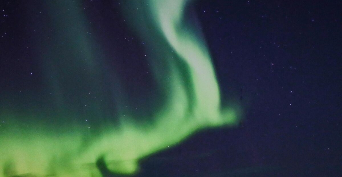 Capture of the mesmerizing green aurora borealis dancing over Troms Norway