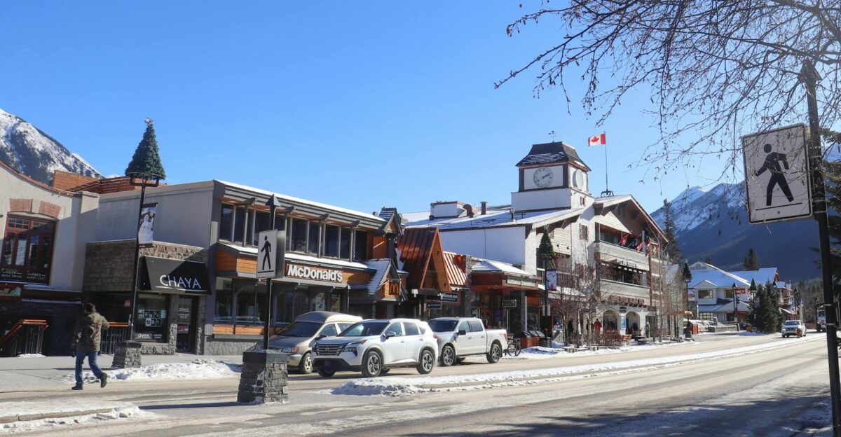 Scenic winter day on Banff Avenue showcasing snowy streets shops and mountains