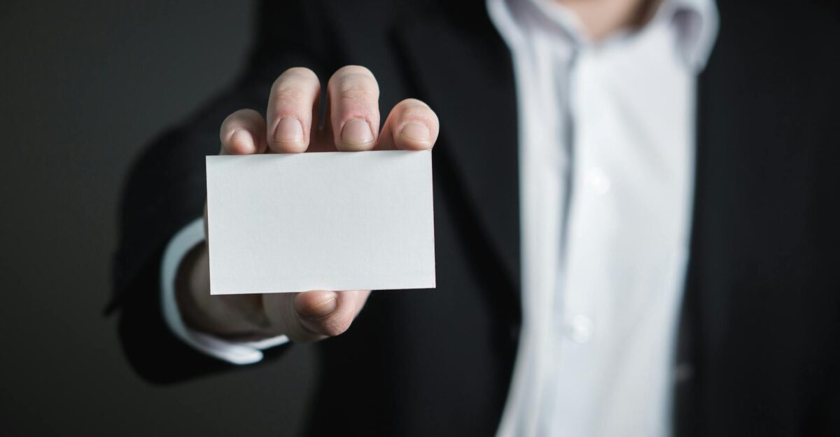 A man in a suit presenting a blank business card for corporate usage