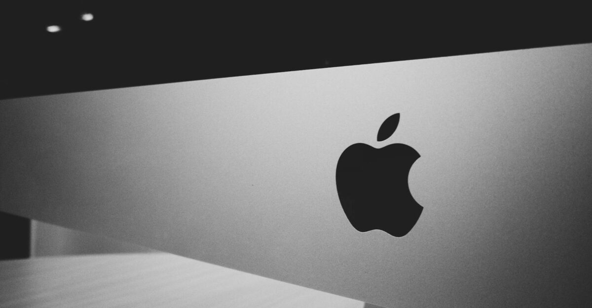 Close-up of a black and white Apple logo on a desktop screen with a modern minimalist design