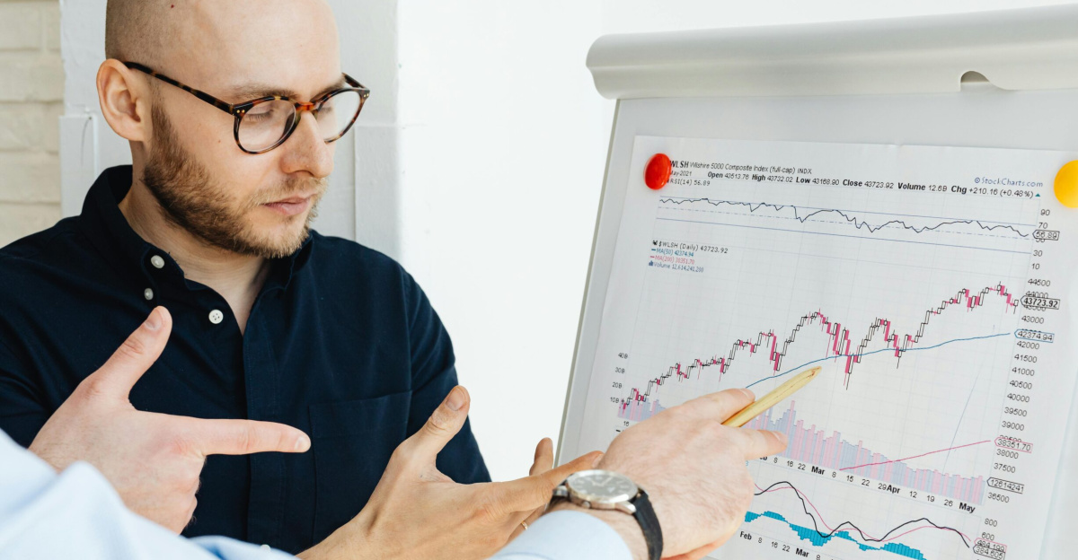 Business professionals discussing financial graphs on a flipchart during a daylight meeting.