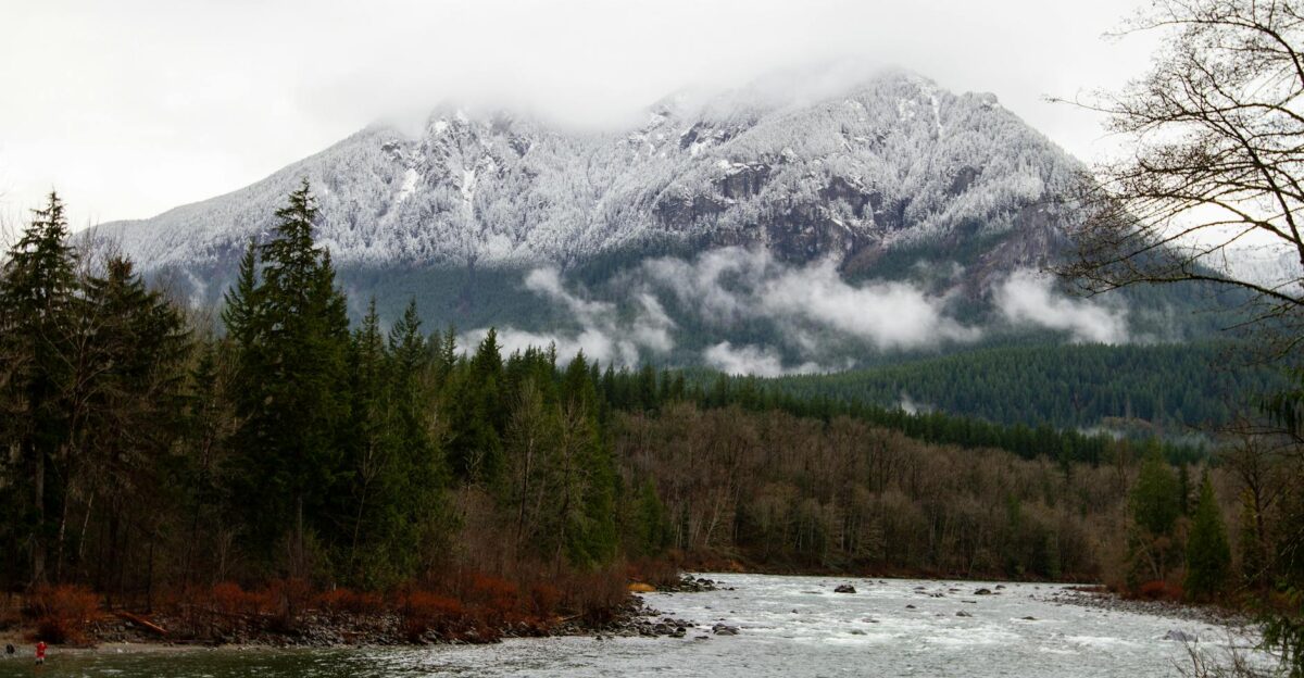Breathtaking view of the Snohomish River flowing through a forested landscape with snow-capped mountains in Washington