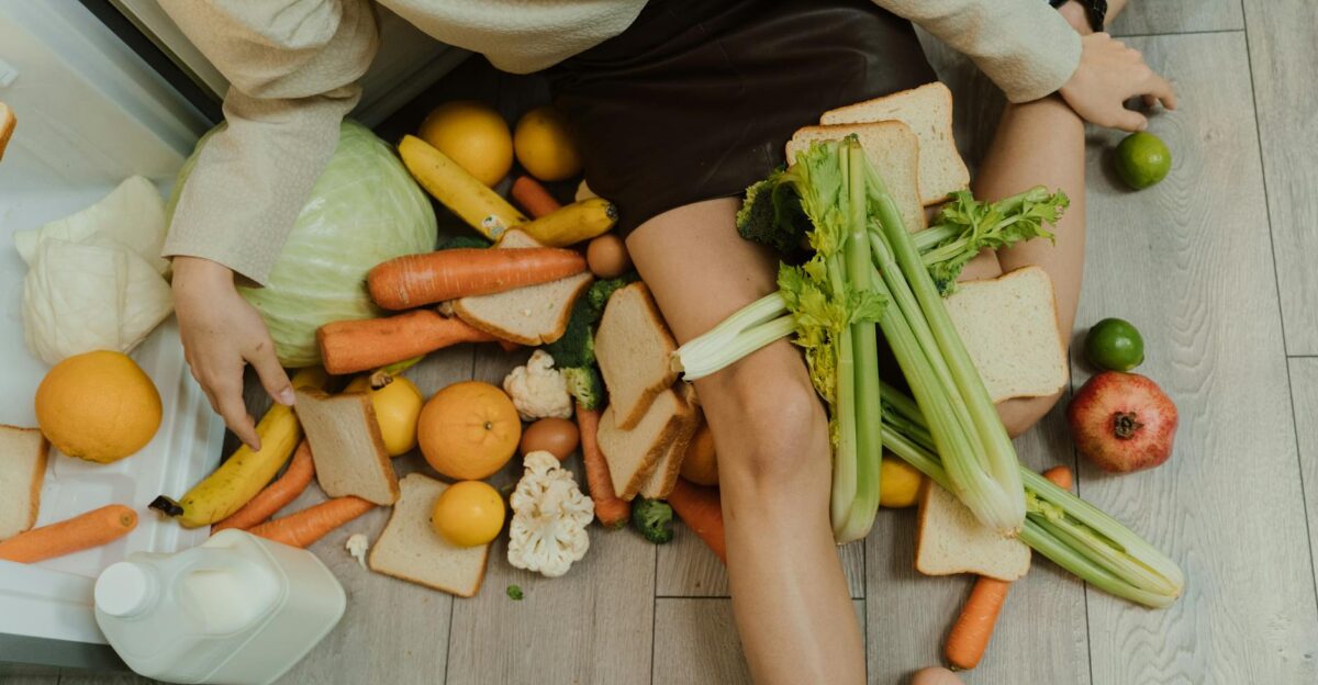 A woman amidst spilled groceries highlighting food waste and consumerism with vegetables fruits and bread