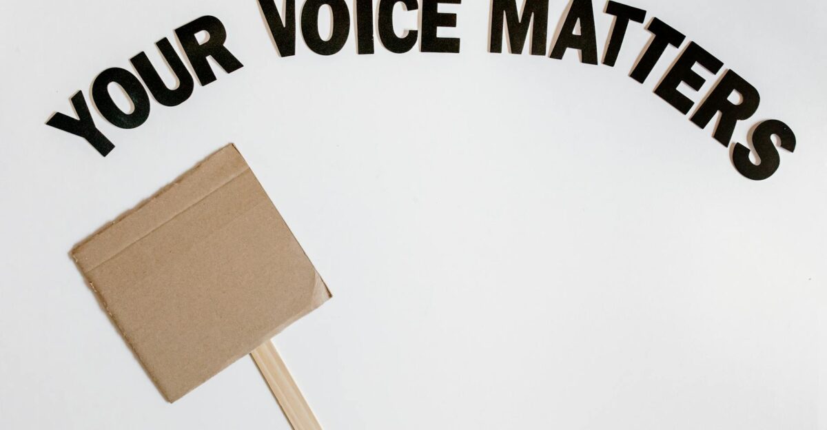 Cardboard protest sign with text Your Voice Matters emphasizes empowerment and advocacy