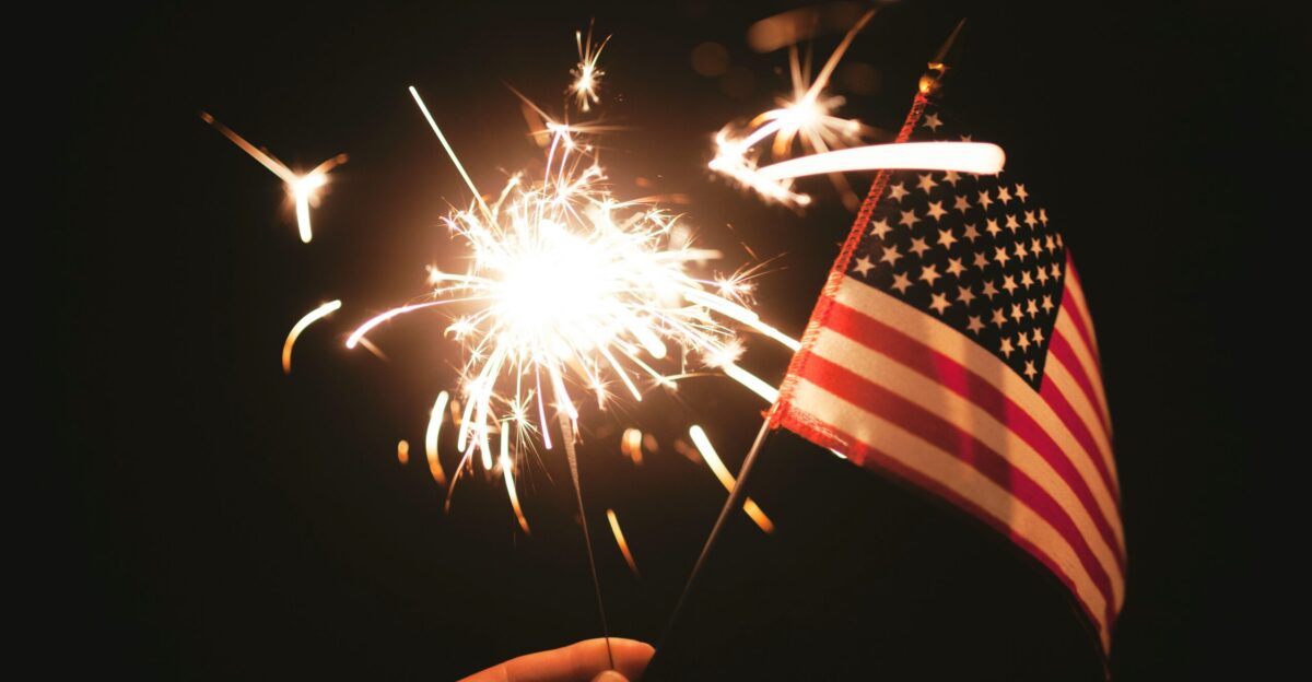 time lapse photography of sparkler and U S A flag let