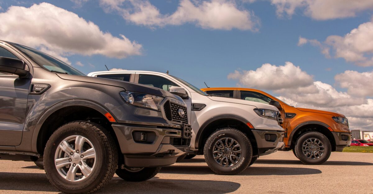 white and black suv on gray asphalt road under blue and white sunny cloudy sky during