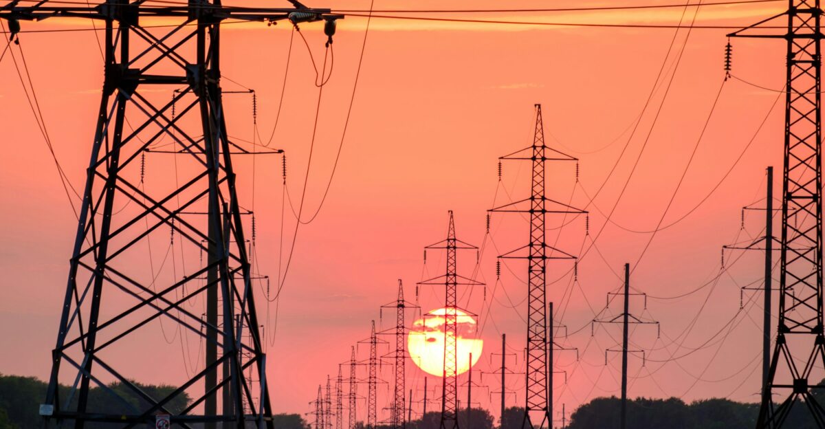 silhouette of electric post during sunset