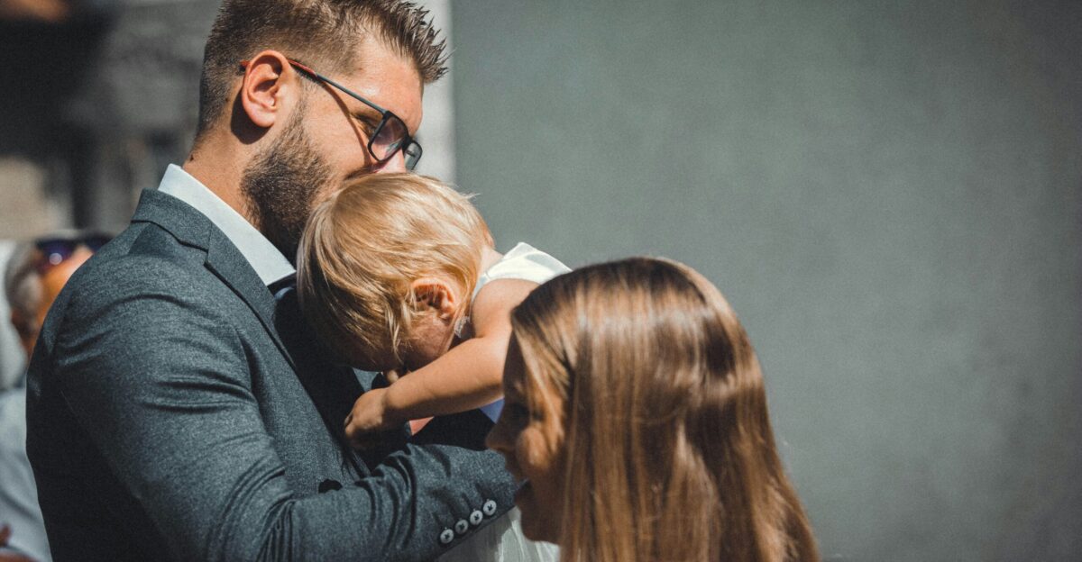 a man in a suit holding a small child