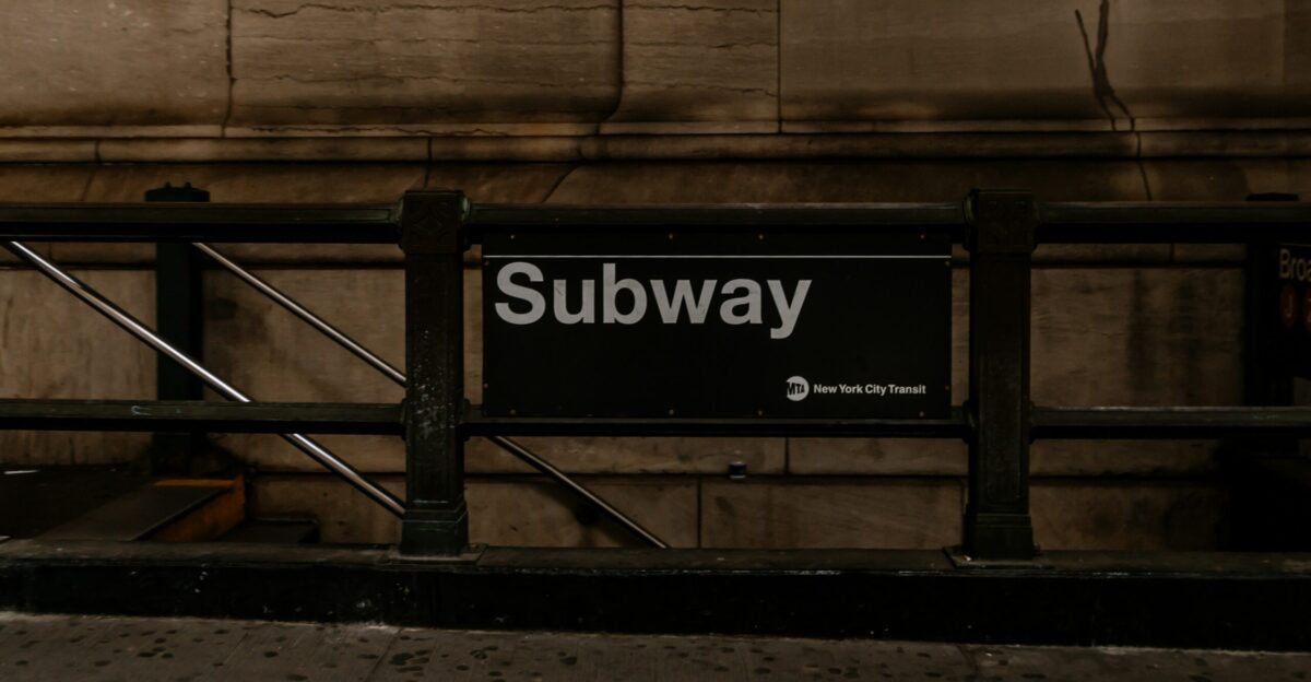 a subway sign sitting on the side of a building