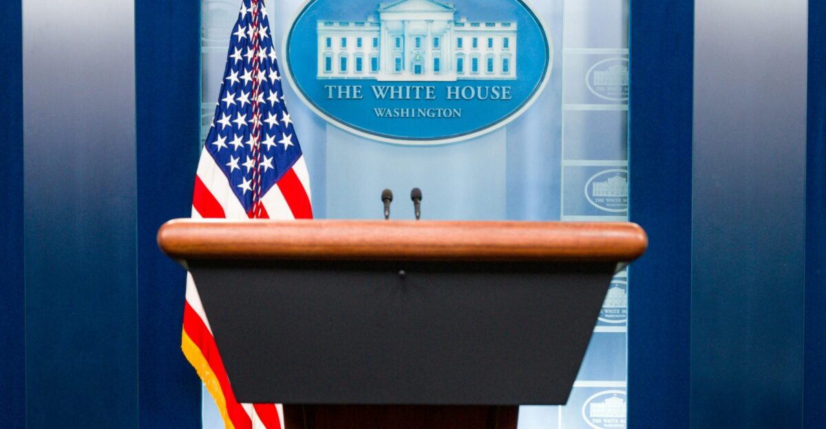 a podium with an american flag and the white house