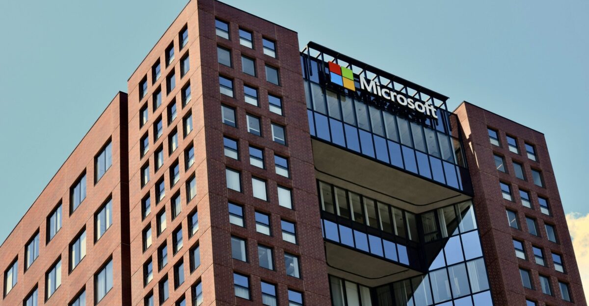 a tall brick building with windows and a sky background