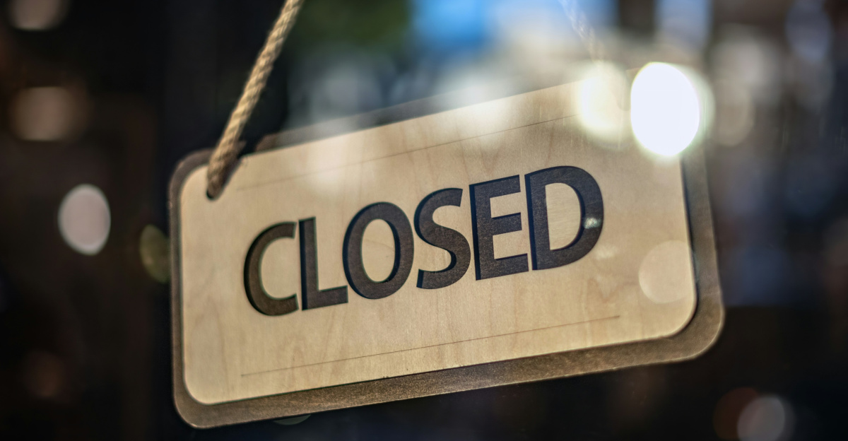 A closed sign hanging from a glass door