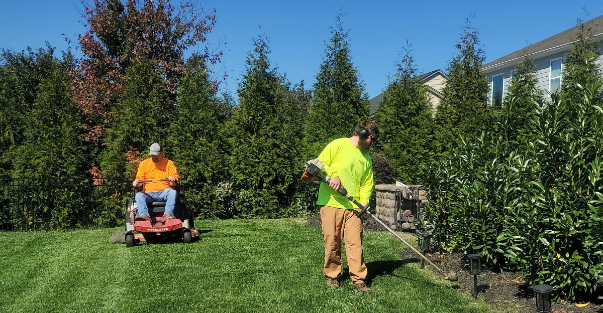 A man mowing a lawn with a lawn mower
