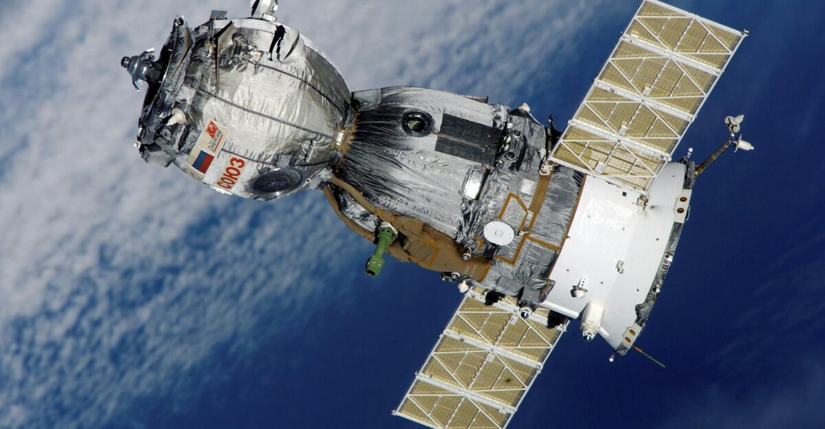 Close-up of Soyuz spacecraft orbiting Earth with solar panels extended showcasing space exploration technology