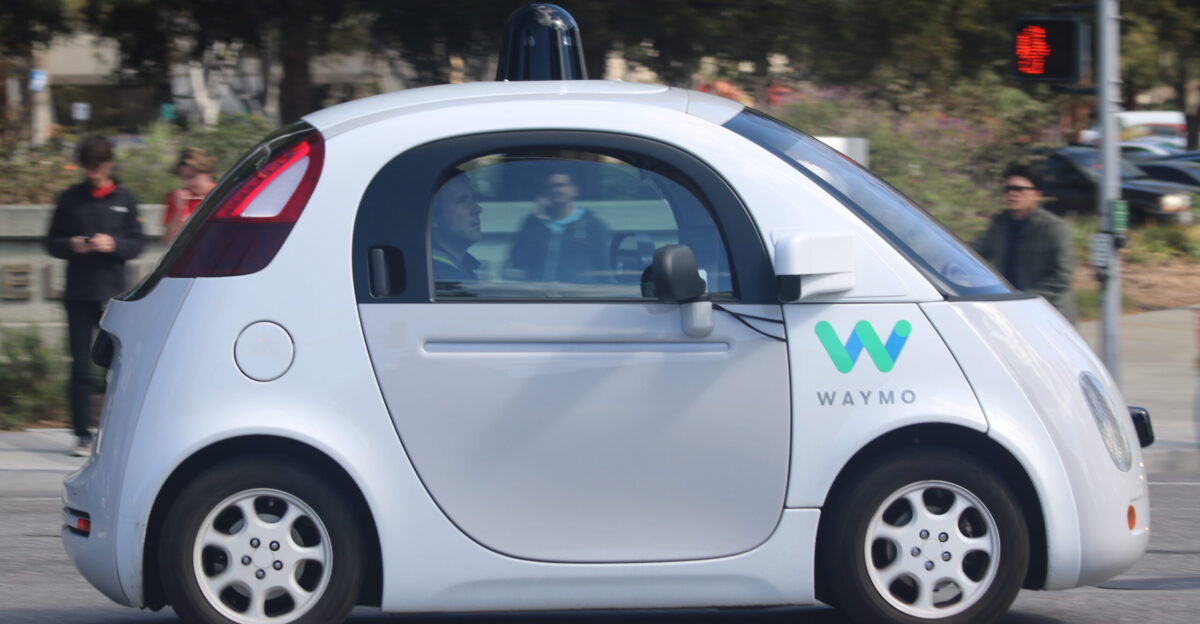 A Waymo self-driving car on the road in Mountain View making a left turn Side view