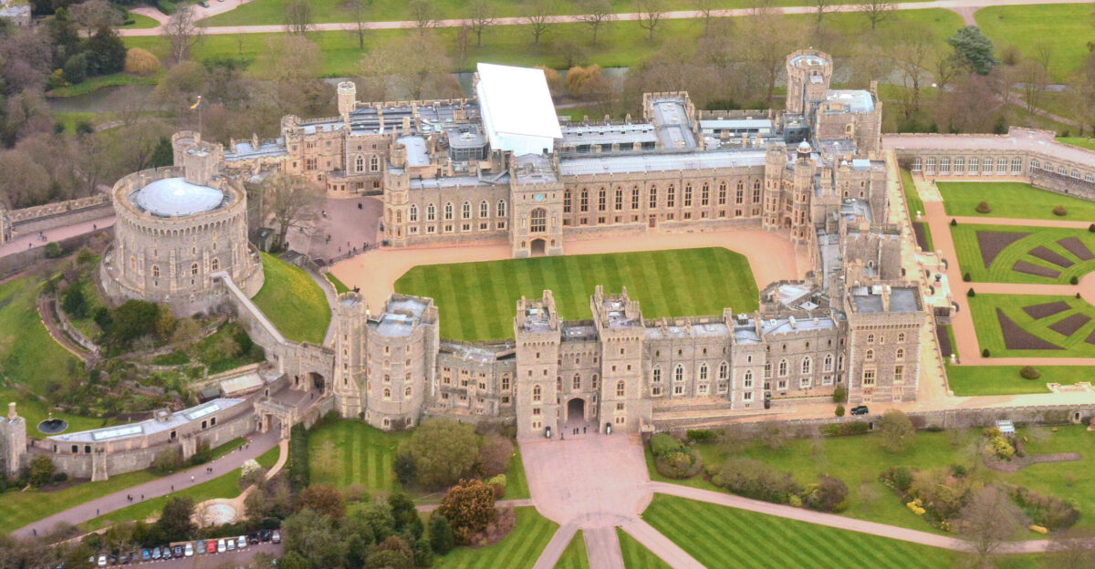 One of the places the Queen lives in when outside London It s located to the West of London not far from Heathrow Airport It s the location of the wedding of Prince Harry Henry to Meghan Markle on 19 May 2018 Windsor Castle is the oldest and largest inhabited castle in the world and has been the family home of British kings and queens for almost 1 000 years It is an official residence of Her Majesty The Queen and is still very much a working royal palace today home to around 150 people If you zoom in and look at the entrance you may - just - be able to see a Royal Guard marching from one side to the other past 3 other people standing there On the Round Tower at the left I think I see the Royal Standard flying - the Queen s personal flag which would indicate that when I took the picture she was in residence at the castle